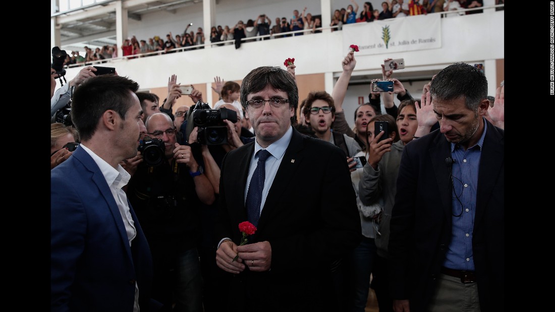 Catalan President Carles Puigdemont, center, arrives to inspect a sports hall as police interve in Girona, Spain. Puigdemont condemned &quot;indiscriminate aggression&quot; against peaceful voters.