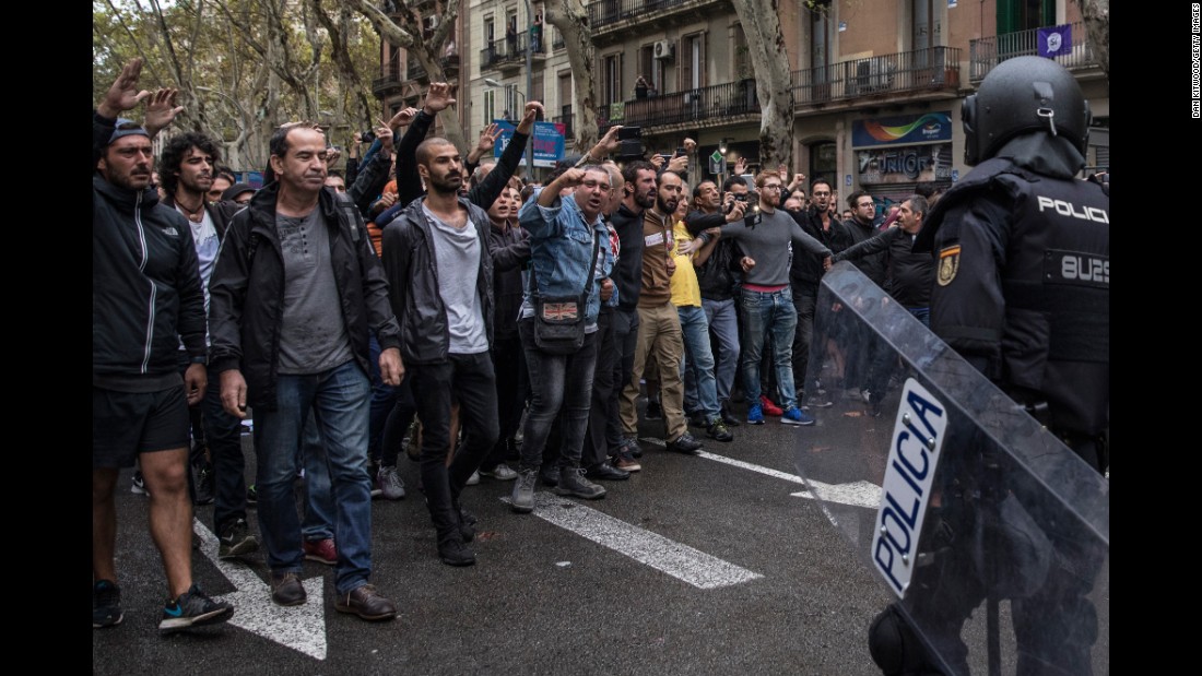 Pro-referendum supporters clash with members of the Spanish National Police after police tried to enter a polling station to retrieve ballot boxes.