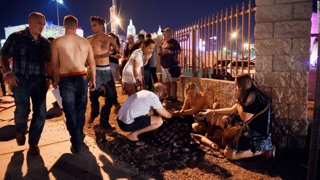 People gather around a victim outside the festival grounds.