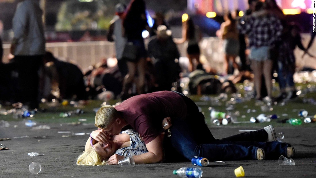 A man lays on top of a woman as others flee the festival grounds. The woman reportedly got up from the scene. 