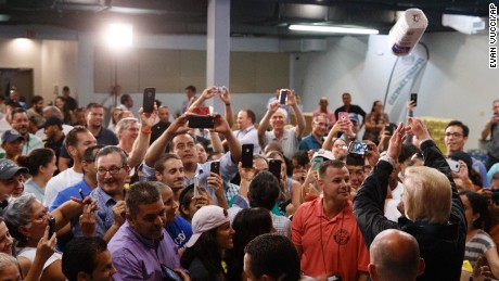 President Donald Trump tosses paper towels into a crowd as he hands out supplies at Calvary Chapel on October 3, 2017, in Guaynabo, Puerto Rico.