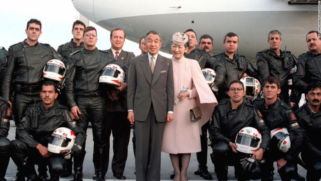 Akihito and Michiko pose with police officers who had escorted them at Brazil&#39;s Curitiba Airport in 1997.