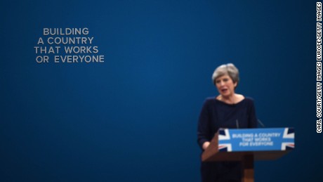  An &#39;F&#39; falls off the backdrop as British Prime Minister Theresa May delivers her keynote speech.