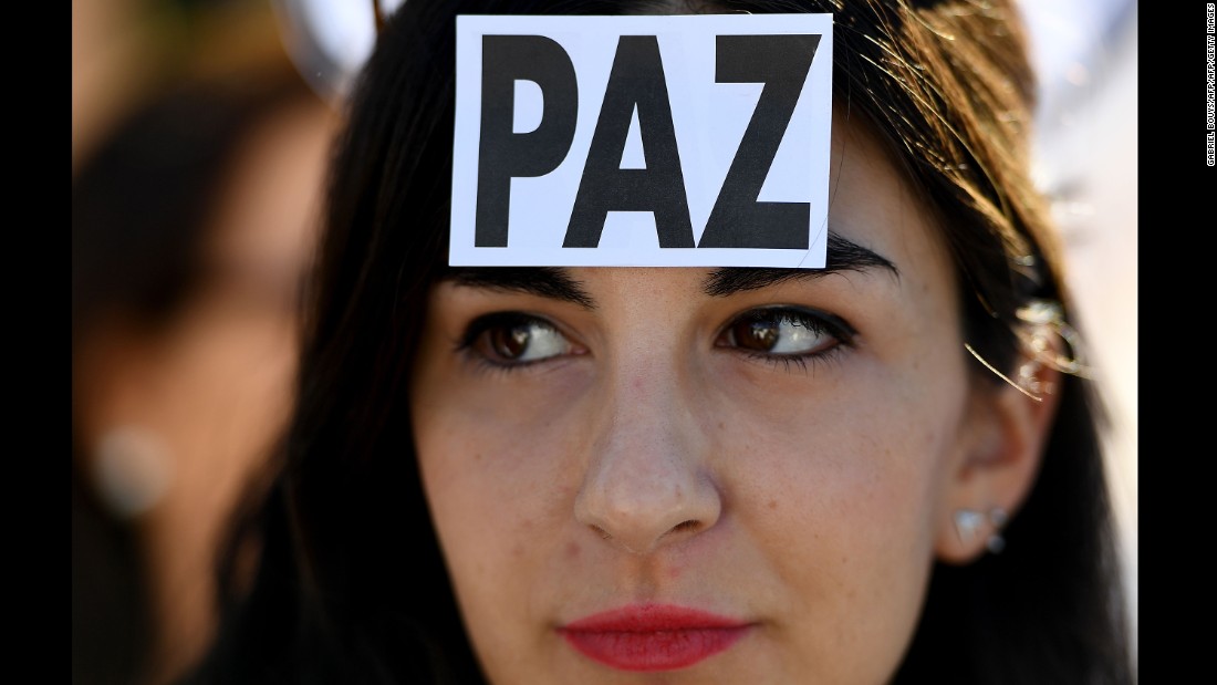 A woman wears a sticker with the Spanish word for &quot;peace&quot; at a demonstration in Madrid on October 7.