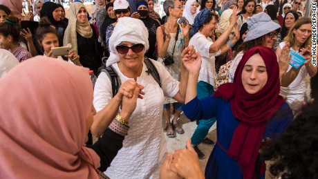 Israeli and Palestinian women dance together under a large tent during the mass protest.