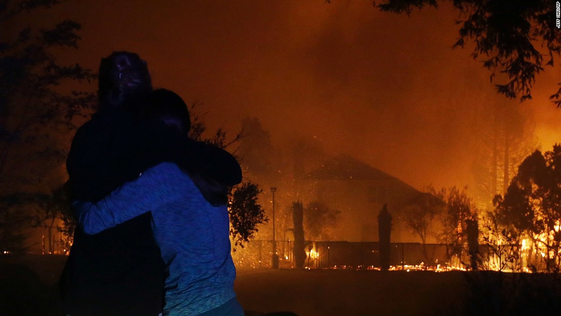 Two women hug as they watch houses burn in Santa Rosa on October 9.