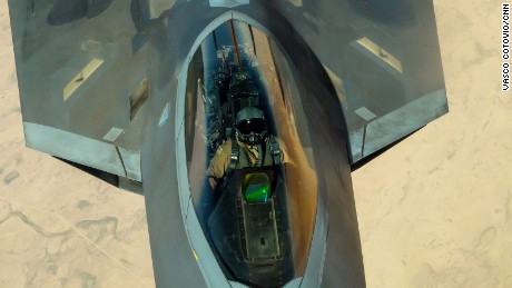 The pilot of an F-22 fighter jet looks up at the boom operator of a KC-10 Extender as his plane is refueled in mid-air over the Middle East.