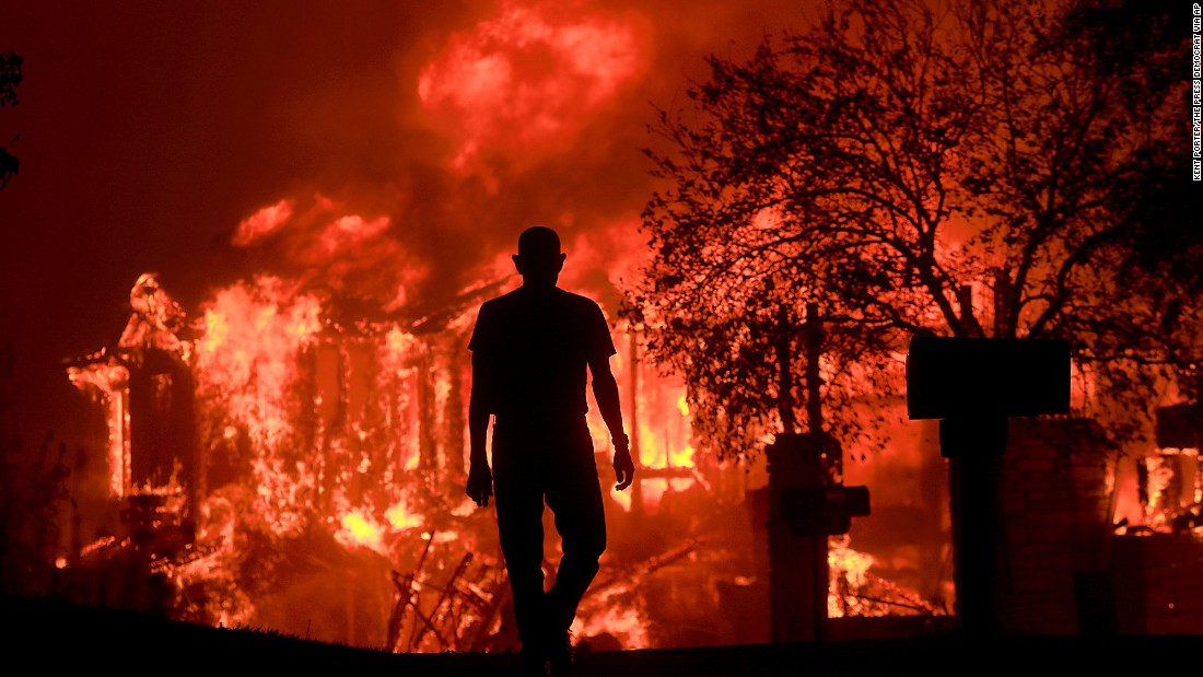 Jim Stites watches as part of his neighborhood burns in Fountaingrove on October 9. 