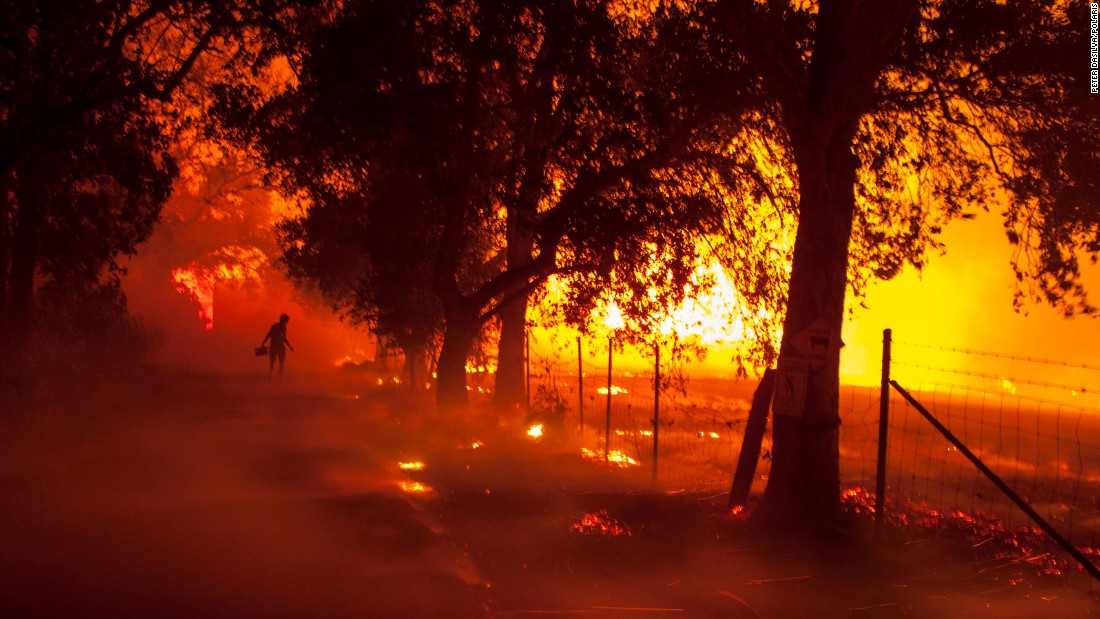 A TV cameraman inches closer to a burning building at a winery in Napa Valley on Monday, October 9. 