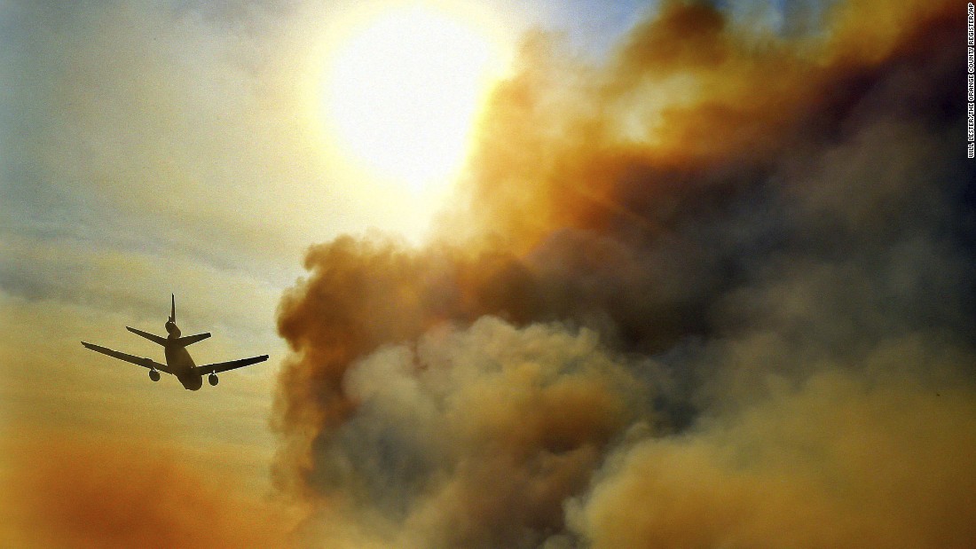 A firefighting plane helps battle a blaze just north of Tustin on October 9.