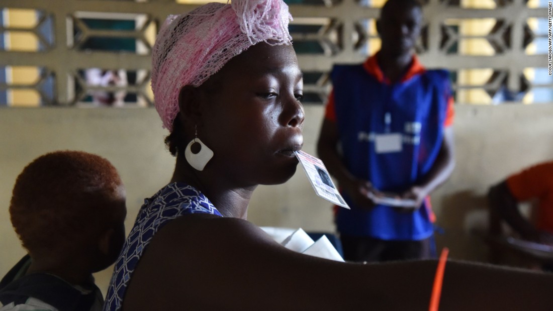 A woman carrying a child on her back casts her ballot. &lt;br /&gt;&lt;br /&gt;Credit: Getty images