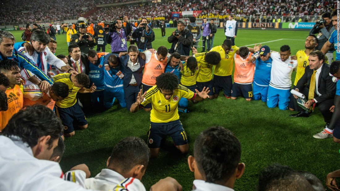 Colombia&#39;s Juan Cuadrado (C) leads a prayer after his team qualified for the 2018 World Cup following the 1-1 draw with with Peru in Lima. Colombia reached the quarterfinals in the 2014 tournament before losing 2-1 to hosts Brazil.