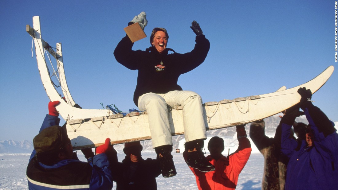 A winner is lifted atop a traditional dog sled after victory...