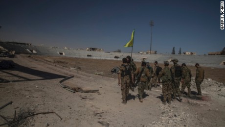 Soldiers of SDF reaching inside of stadium to put the flag.
Syria, Raqqah - October 17, 2017