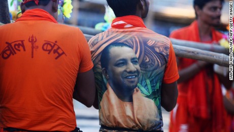 A Hindu devotee, wearing a t-shirt with a photo of Uttar Pradesh Chief Minister Yogi Adityanath, stands on the bank of Ganges, July 14, 2017. 