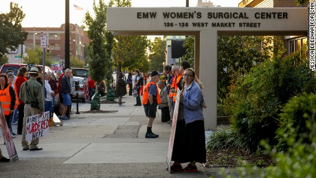Anti-abortion demonstrators and volunteer clinic escorts are seen outside the EMW Women&#39;s Surgical Center in Louisville, Ky. on Aug. 26, 2017. The volunteer escorts wear vests to identify themselves.