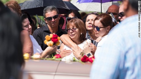 Evelyn Cruz Rivera, one of Isabel Rivera&#39;s five children, stands at her mother&#39;s coffin.
