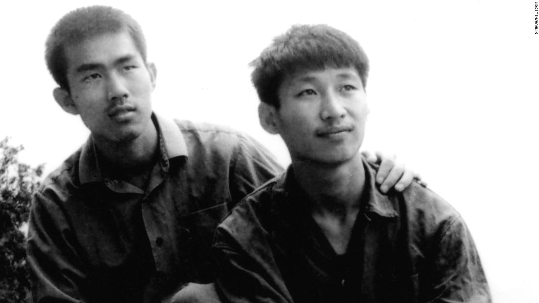 Xi, right, poses for a photo as a college student in 1977.