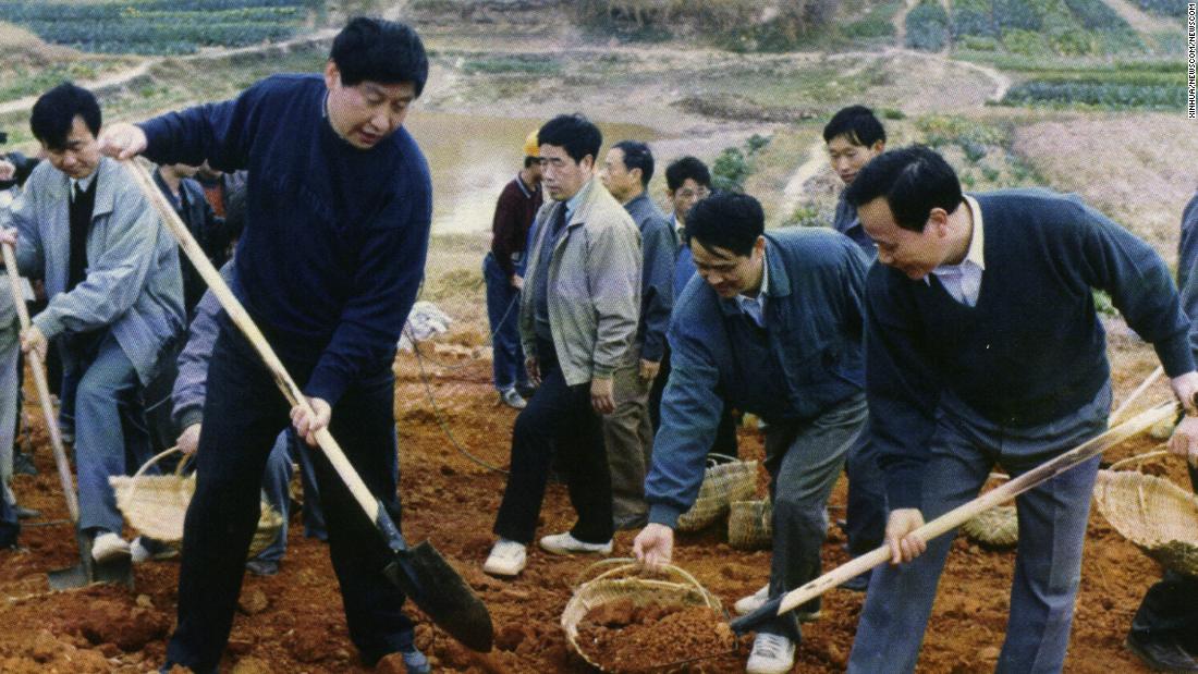 Xi, front left, helps reinforce a levee of the Minjiang River in 1995.