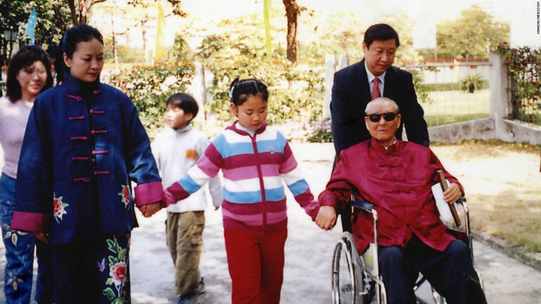 Xi pushes his father as he walks with his wife and his daughter, Xi Mingze, in 2012.