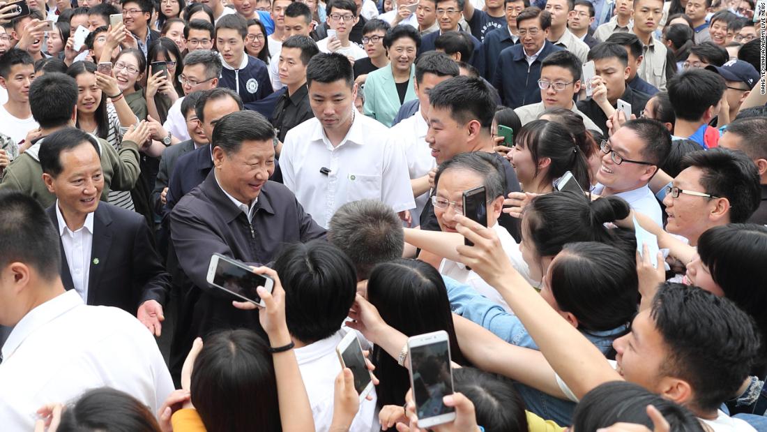 Xi shakes hands with teachers and students while visiting a university in Beijing in May 2017.