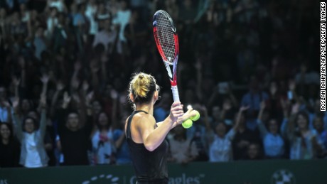 Simona Halep of Romania hits a ball for supporters after defeating Agnieszka Radwanska of Poland during the semi finals of the Women&#39;s Tennis Association (WTA) finals in Singapore on October 25, 2014. AFP PHOTO / ROSLAN RAHMAN        (Photo credit should read ROSLAN RAHMAN/AFP/Getty Images)