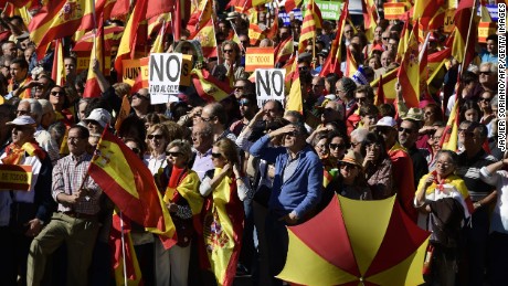 People hold signs reading &quot;No to the coup&quot; while waving Spanish flags during a demonstration urging unity in Madrid on Saturday.