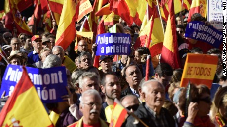 TOPSHOT - People hold signs reading "(Catalan regional president Carles) Puigdemont to prison"  while waving Spanish flags during a demonstration calling for unity at Plaza de Colon in Madrid on October 28, 2017, a day after direct control was imposed on Catalonia over a bid to break away from Spain.
Spain moved to assert direct rule over Catalonia, replacing its executive and top functionaries to quash an independence drive that has plunged the country into crisis and unnerved secession-wary Europe. / AFP PHOTO / JAVIER SORIANOJAVIER SORIANO/AFP/Getty Images