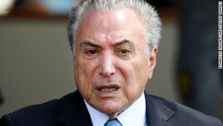Brazilian President Michel Temer attends the award ceremony of the Order of Aeronautical Merit at an air base in Brasilia, on October 23, 2017. 
The first president in the country to face criminal charges while in office, Temer is accused of obstruction of justice and racketeering. He denies any wrongdoing and has argued that the country needs him at the helm to bring in market-friendly reforms after two years of deep recession. This week the chamber of deputies must vote the request to authorise the opening of an investigation against the ruling President. / AFP PHOTO / EVARISTO SA        (Photo credit should read EVARISTO SA/AFP/Getty Images)