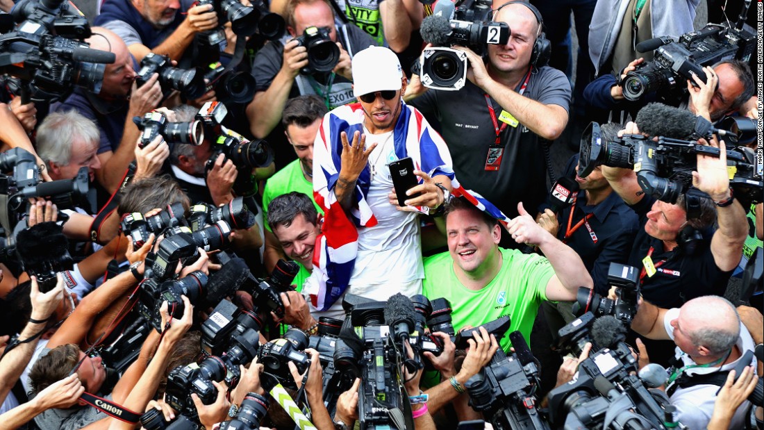 Hamilton poses for the cameras signaling his four world titles. How many more titles can the Briton win?