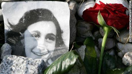 A picture of Anne Frank in front of her memorial stone at the former Bergen-Belsen concentration camp.