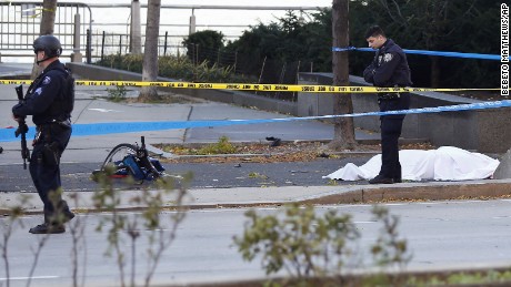 A New York Police Department officer stands next to a body covered under a white sheet near a mangled bike along a bike path Tuesday Oct. 31, 2017, in New York. (AP Photo/Bebeto Matthews)