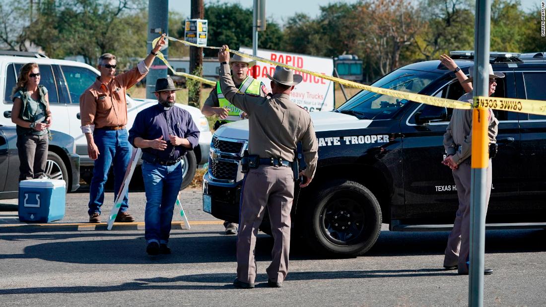 Law enforcement officers man a barricade near the church.