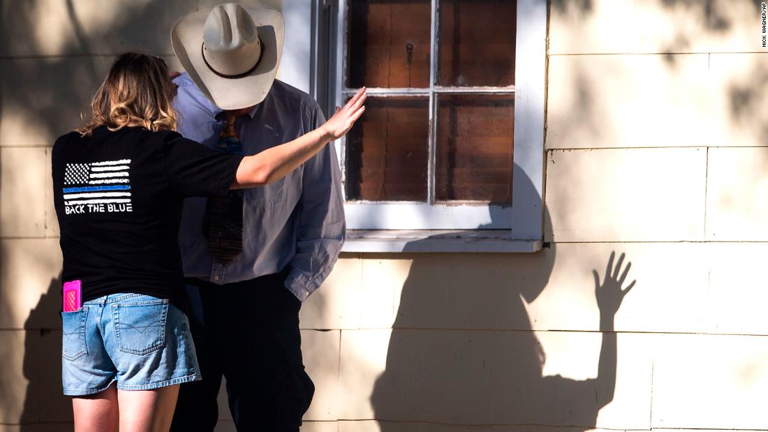 A woman prays with a man after the shooting. 