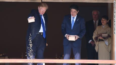 US President Donald Trump (C) feeds koi fish as Japanese Prime Minister Shinzo Abe (R)looks on during a welcoming ceremony in Tokyo on November 6, 2017.
Trump lashed out at the US trade relationship with Japan, saying it was &quot;not fair and open&quot;, as he prepared for formal talks with his Japanese counterpart. / AFP PHOTO / JIM WATSON        (Photo credit should read JIM WATSON/AFP/Getty Images)