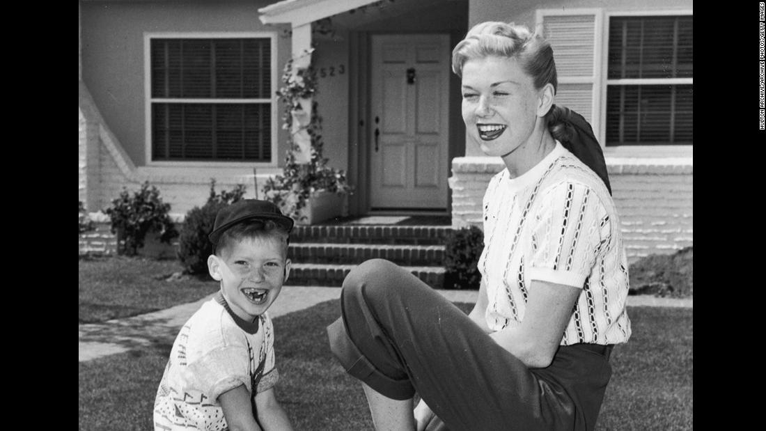 Day sits on a fence with her son, Terry, in front of their home. Terry was her only child.