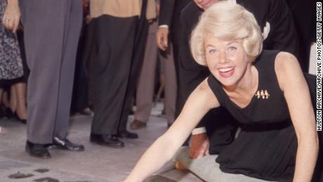 19th January 1961:  American singer and actress Doris Day smiling as she signs her name in cement by her handprints, in front of Mann&#39;s (formerly Grauman&#39;s) Chinese Theater, on Hollywood Boulevard, Hollywood, California.  (Photo by Hulton Archive/Getty Images)