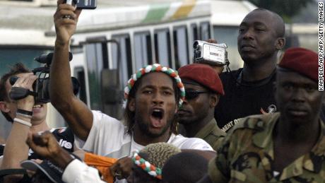 Drogba is seen aboard a military vehicle at Felix Houphouet Boigny airport in October 2005 after qualifying for the World Cup.