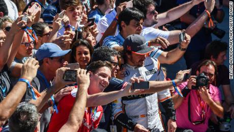 Alonso poses with fans for selfies before the Brazilian Formula One Grand Prix in 2017.