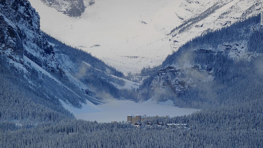 The iconic luxury Fairmont Chateau Lake Louise Hotel sits on the shore of the eponymous lake, which is snow covered in winter and a piercing emerald green in the summer. 