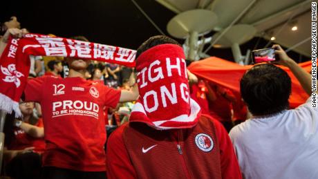 A Hong Kong fan covers his face during the Chinese national anthem before the match between Hong Kong and Bahrain on November 9, 2017.
