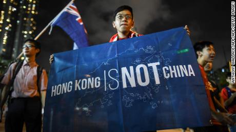 In this October 10, 2017 photograph, a flag that reads &quot;Hong Kong is not China&quot; is displayed by a local football fan in front of the old British colonial flag after a match between Hong Kong and Malaysia in Hong Kong.
