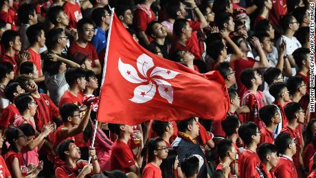 Local football fans hold up the Hong Kong flag during a match against Malaysia in Hong Kong on October 10, 2017.