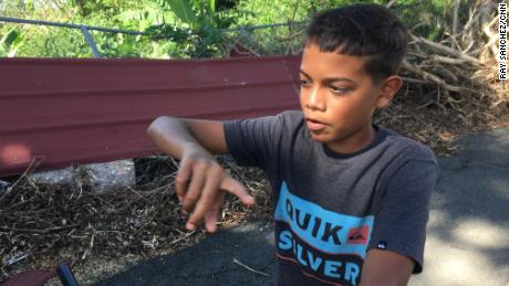 Ian Nieves, 12, outside the school where his family has lived since the storm hit. 