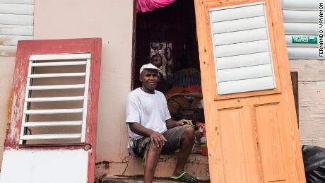 A man waits to replace his damaged door in Christiansted, a day after Maria hit.