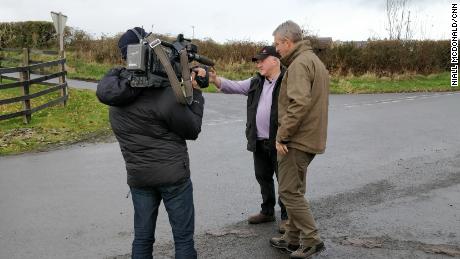 Farmer Francie Ward shows CNN&#39;s Nic Robertson the border along his road.