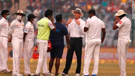 Officiating umpire Nigel Llong, third from right, addresses Sri Lanka's players wearing masks, during a brief break on Sunday's match. 