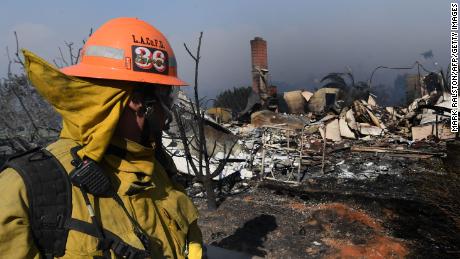 A firefighter looks at a house burnt to the ground during the Thomas wildfire in Ventura, California on December 5, 2017.
Fast-moving, wind-fueled brush fire exploded to about 10,000 acres in Ventura County Monday night, forcing hundreds of people to flee their homes, officials said.  / AFP PHOTO / MARK RALSTONMARK RALSTON/AFP/Getty Images