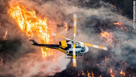 epaselect epa06372496 A Los Angeles County Fire helicopter flies over during the &#39;Skirball Fire&#39; which began early morning in Bel-Air, California, USA, 06 December 2017. An outbreak of several fires North of Los Angeles has occurred as one of the strongest Santa Ana winds forecast of the season is ongoing and expected to last several days.  EPA-EFE/JOHN CETRINO