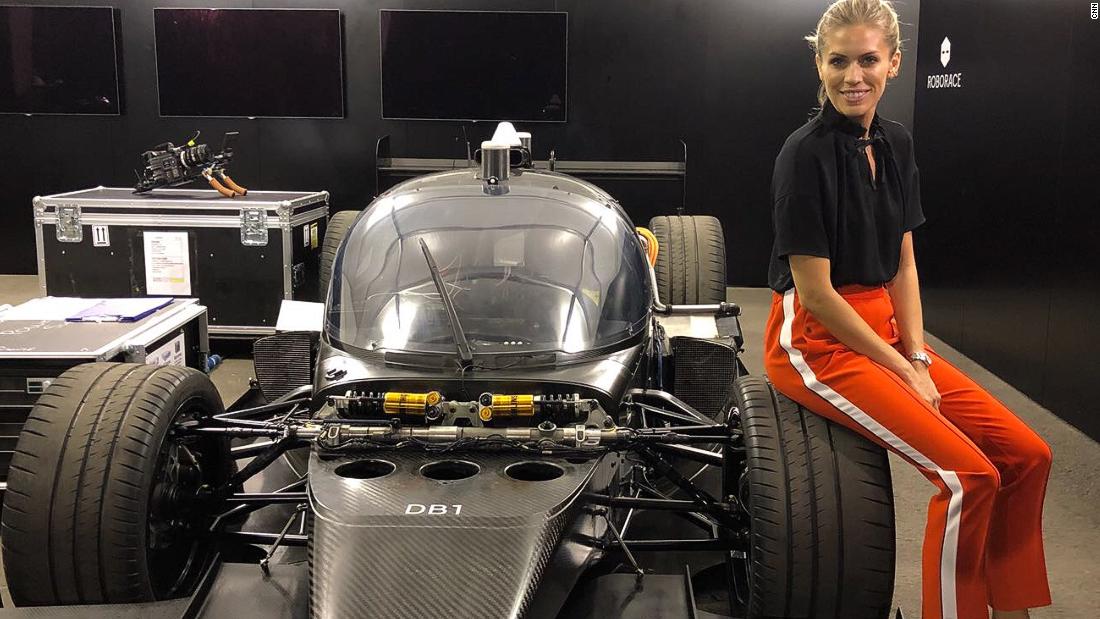 Nicki Shields poses with her rival, the AI race car DevBot at the Hong Kong ePrix earlier in December. 